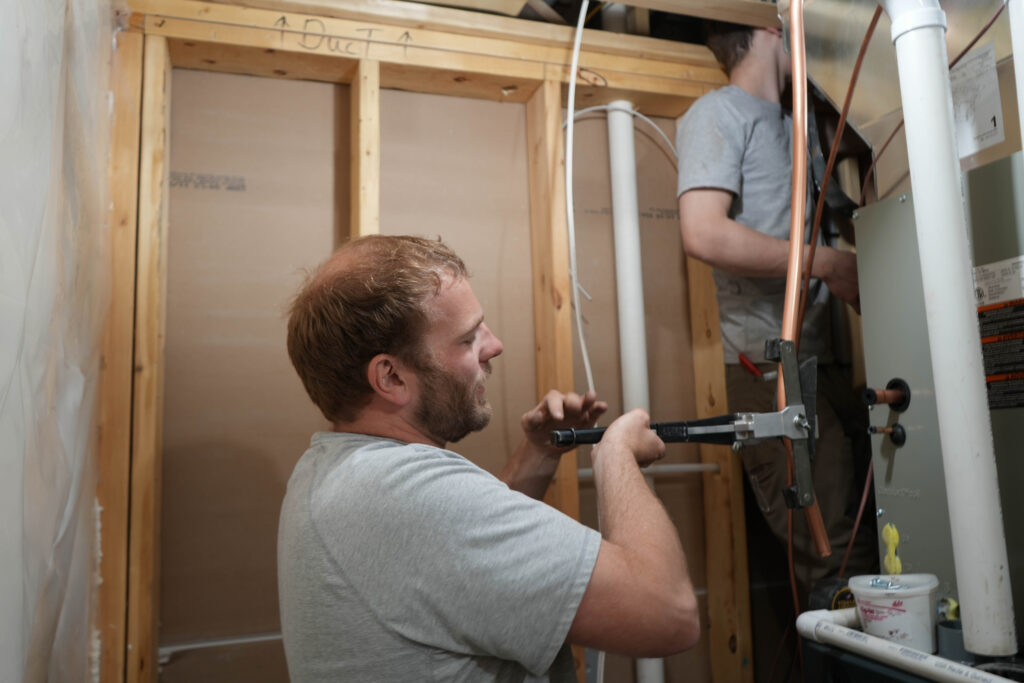 Technician from Woods Heating & Cooling performing furnace repair in a residential home in Spearfish, South Dakota.