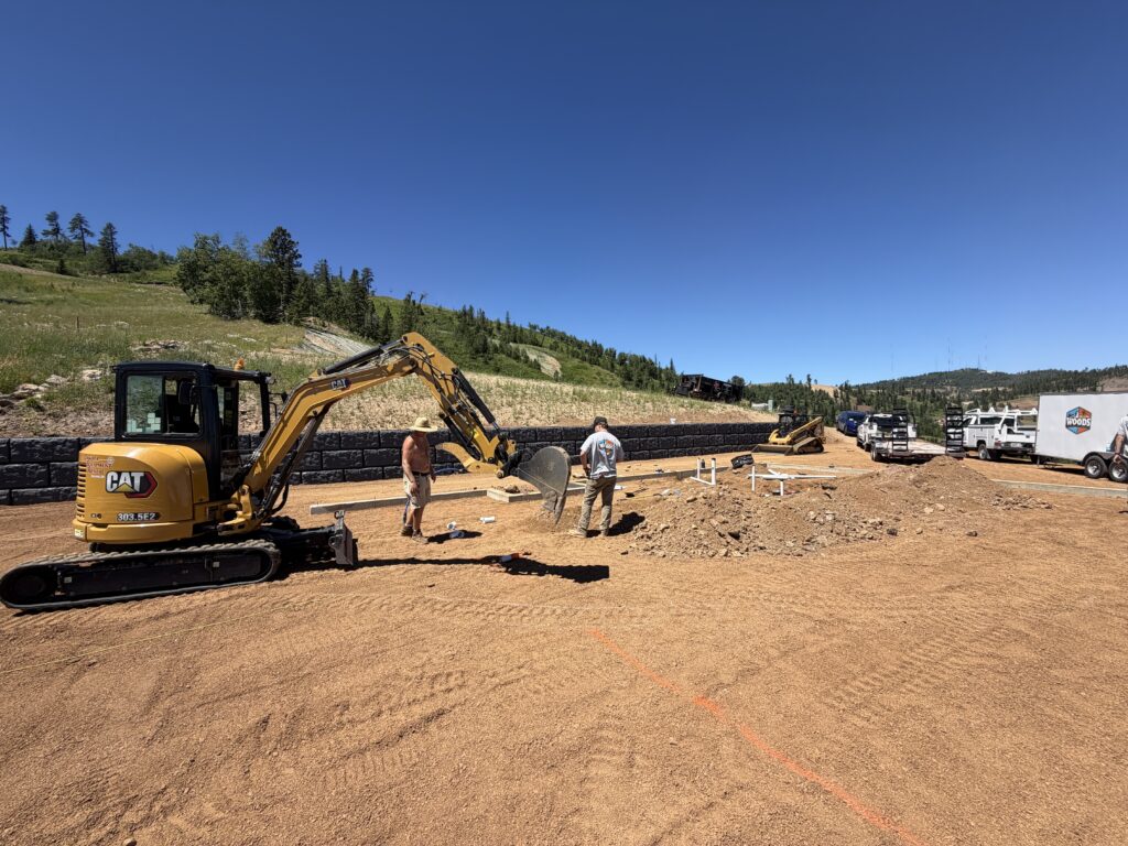 Woods Heating and Cooling crew starting underground plumbing rough-in on a new home site below a ski slope in Deer Mountain Village near Lead, SD.