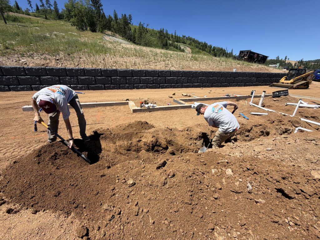Woods Heating and Cooling plumbers trenching for underground plumbing rough-in at a new home in Deer Mountain Village near Lead, SD.
