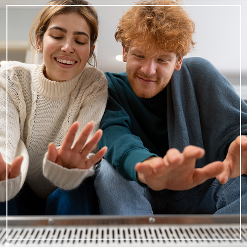 Married couple enjoying heat from heater in home installed by Woods Heating and Cooling in Spearfish, SD.