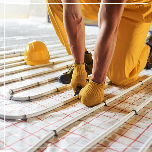 HVAC contractor installing piping and electrical cords in floor heating services in custom home in Spearfish, SD.