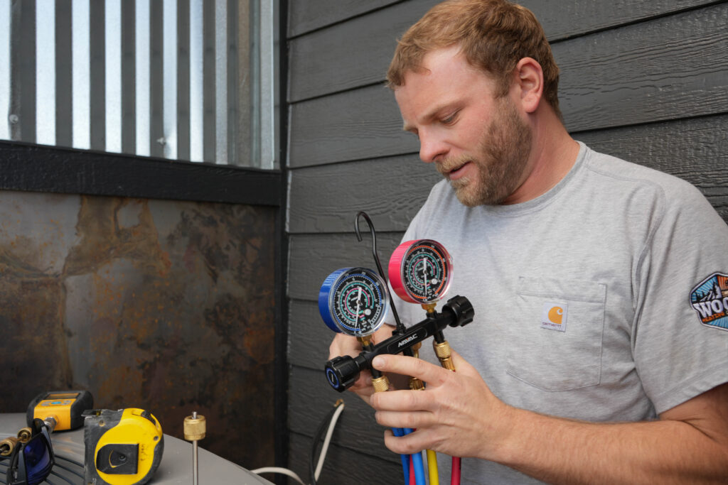 McKinley Bickett, the owner of Woods Heating & Cooling installs new air conditioner in New Construction HVAC services.