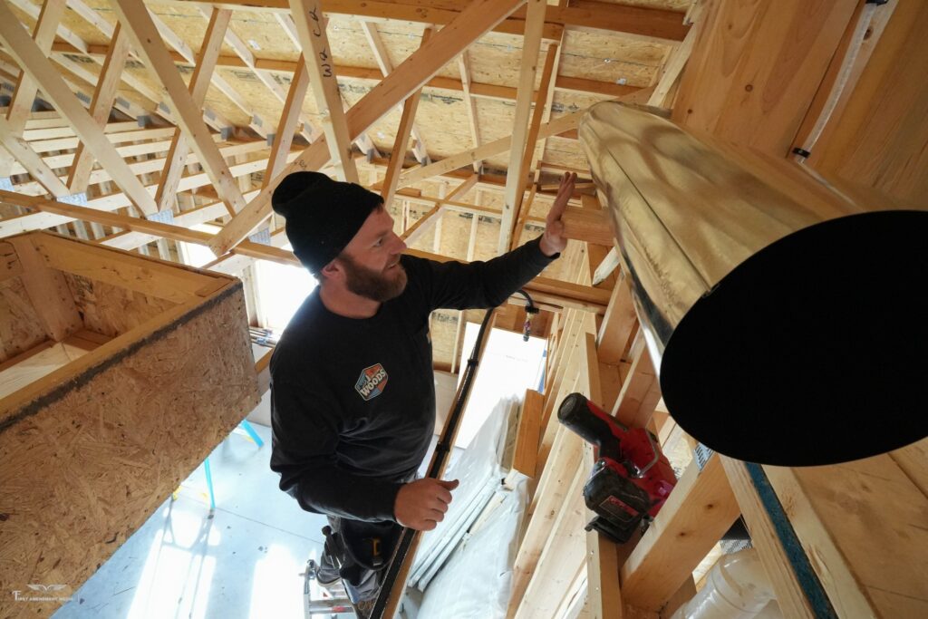 Wood’s Heating & Cooling technician installing furnace venting in a residential attic in Spearfish, SD